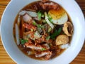 Top view of chinese roll noodle soup with crispy pork, boiled egg and tofu sprinkled Royalty Free Stock Photo