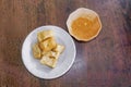 Top view Chinese snack and vegetarian food `Fried Tofu` on white ceramic plate and peanut sweet and sour spicy sauce