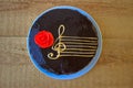Top View Of A Chocolate Cake With A Stylized Image Of A Musical Staff Stave With A G-Clef And A Red Rose On A Wooden Background Royalty Free Stock Photo