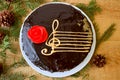 Top View Of A Chocolate Cake With A Stylized Image Of A Musical Staff Stave With A G-Clef And A Red Rose On A Wooden Background Royalty Free Stock Photo