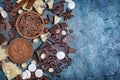 Top view of chocolate chips, pieces of dark and white bars with whole hazelnuts and cocoa powder with spices for confectionery