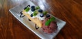 Top view of Chocolate ice cream with sliced fresh kiwi, berry or raspberry and whipped cream in plate or dish on wooden table Royalty Free Stock Photo