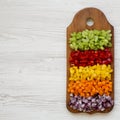 Top view, chopped fresh vegetables carrot, celery, red onion, colored peppers arranged on cutting board on a white wooden Royalty Free Stock Photo