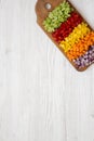 Top view, chopped fresh vegetables carrot, celery, red onion, colored peppers arranged on cutting board on a white wooden Royalty Free Stock Photo