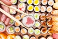 Top view of chopsticks with roll over many sushi