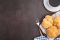 Top view of choux cream on a plate and a white coffee cup on a table. Royalty Free Stock Photo