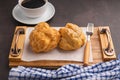 Top view of choux cream on a plate on a wooden tray and a white coffee cup on a table. Royalty Free Stock Photo