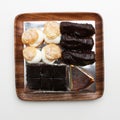 Top view of choux pastry buns, cheesecake and eclairs on a wooden plate Royalty Free Stock Photo