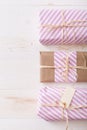 Top view on Christmas, birthday or any other celebration gift wrapped in pink striped paper and decorated with ribbon Royalty Free Stock Photo