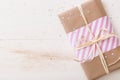 Top view on Christmas, birthday or any other celebration gift wrapped in pink striped paper and decorated with ribbon and tag on Royalty Free Stock Photo