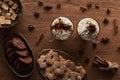 Top view of Christmas cacao near cookies, anise, cinnamon and brown sugar on wooden table.