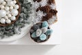 Top view christmas decorations centerpiece with garland and balls near a basket with colorful pine cones isolated on a white table