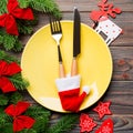 Top view of Christmas dinner on wooden background. Plate, utensil, fir tree and holiday decorations with copy space. New Year time Royalty Free Stock Photo