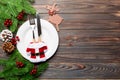 Top view of Christmas dinner on wooden background. Plate, utensil, fir tree and holiday decorations with copy space. New Year time Royalty Free Stock Photo