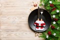 Top view of Christmas dinner on wooden background. Plate, utensil, fir tree and holiday decorations with copy space. New Year time Royalty Free Stock Photo