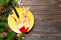 Top view of Christmas dinner on wooden background. Plate, utensil, fir tree and holiday decorations with copy space. New Year time Royalty Free Stock Photo