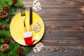 Top view of Christmas dinner on wooden background. Plate, utensil, fir tree and holiday decorations with copy space. New Year time Royalty Free Stock Photo