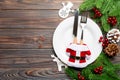 Top view of Christmas dinner on wooden background. Plate, utensil, fir tree and holiday decorations with copy space. New Year time Royalty Free Stock Photo