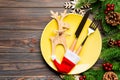 Top view of Christmas dinner on wooden background. Plate, utensil, fir tree and holiday decorations with copy space. New Year time Royalty Free Stock Photo