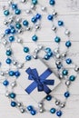 Top view Christmas gift with blue ribbon and silver and blue Christmas balls on white wooden background Royalty Free Stock Photo