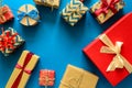 Top view on Christmas gifts wrapped in gift paper decorated with ribbon on blue paper background. Royalty Free Stock Photo