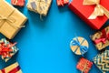 Top view on Christmas gifts wrapped in gift paper decorated with ribbon on blue paper background Royalty Free Stock Photo