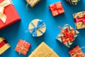 Top view on Christmas gifts wrapped in gift paper decorated with ribbon on blue paper background. Royalty Free Stock Photo