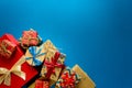 Top view on Christmas gifts wrapped in gift paper decorated with ribbon on blue paper background. Royalty Free Stock Photo