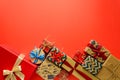 Top view on Christmas gifts wrapped in gift paper decorated with ribbon on red paper background. Royalty Free Stock Photo