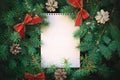 Top view of christmas new year wishes paper card note with frame of fluffy needless spruce tree, bows, pine cones.