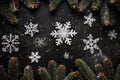 Top view Christmas snowflakes, fir tree branches on wooden black background. Royalty Free Stock Photo