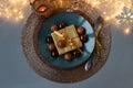 Top view on Christmas table setting. Golden decoration with gift box, glass baubles and defocused lights. Christmas and New Year Royalty Free Stock Photo