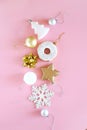 Top view of Christmas tree decorations snowflakes, stars, balls, donuts of gold, white and silver on a pink Royalty Free Stock Photo