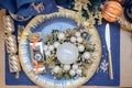 Top view Christmastime table setting, festive dinnerware decorated with details and balls in Blue and Gold colors. Navy Blue Table Royalty Free Stock Photo