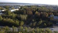 Top view of city on background of river and autumn forest. Clip. Landscape of town with trees on autumn sunny day. Town