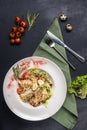 Top view on classic Caesar salad with grilled chicken breast and half of quail eggs in white ceramic plate. Green tablecloth, Royalty Free Stock Photo