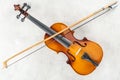 Top view of classical cello with bow on grey background.