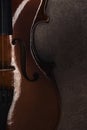 Top view of classical cello on grey textured surface in darkness.