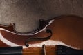 Top view of classical wooden cello on grey textured surface in darkness.