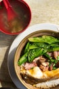 Clay pot rice with fish and pickled duck and vegetable vertical composition