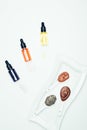 top view of clay powder, cosmetic bottles with pipes, plate and spoons with various colorful clay masks