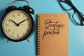 Top view of clock, eyeglasses and notebook written with STRATEGIC PARTNER