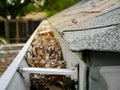 Top view clogged dirty gutter backyard residential home in Dallas, Texas, USA, full of dried leaves, twig, debris on eavestrough Royalty Free Stock Photo