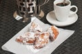 Four homemade, freshly baked beignet fritters on white napkin