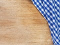 Top view, close-up of blue and white checkered fabric or napkin on wooden table background. Concept kitchen utensils and tableware Royalty Free Stock Photo