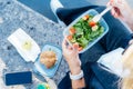 Top view close up business woman eating salad from her lunch box sitting on the bench at office park. Balanced diet Royalty Free Stock Photo