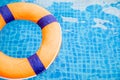 Top view and close up with copy space of orange swim ring for lifeguard and safety on the clear water with ripple wave of the Royalty Free Stock Photo