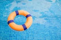 Top view and close up with copy space of orange swim ring for lifeguard and safety on the clear water with ripple wave of the Royalty Free Stock Photo