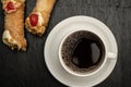 Top view and close-up cup of coffee accompanied with two cannoli.