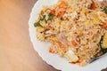 Top view, close up and focus on fried rice mixed with various vegetables and meats in white plate place on dark brown wooden Royalty Free Stock Photo